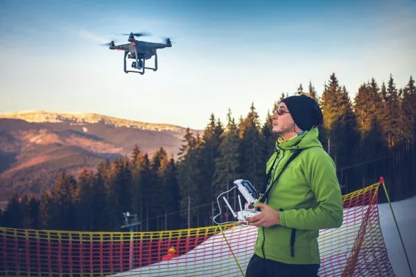 Mies lennättää dronea