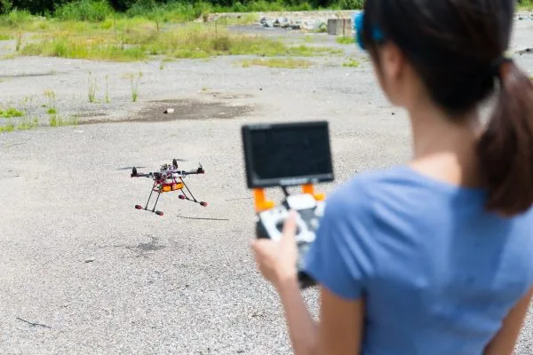 Nainen lennättää dronea